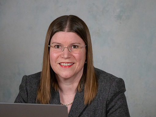 Portraitfoto von Rechtsanwältin Sibylle Schwarz hinter einem Laptop